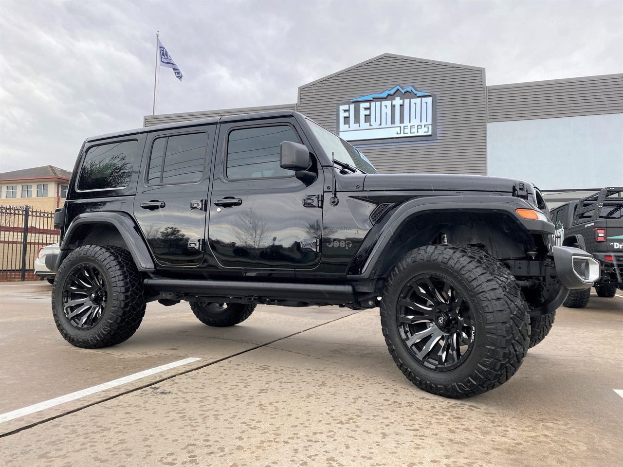 A black Jeep Wrangler Unlimited outside the shop