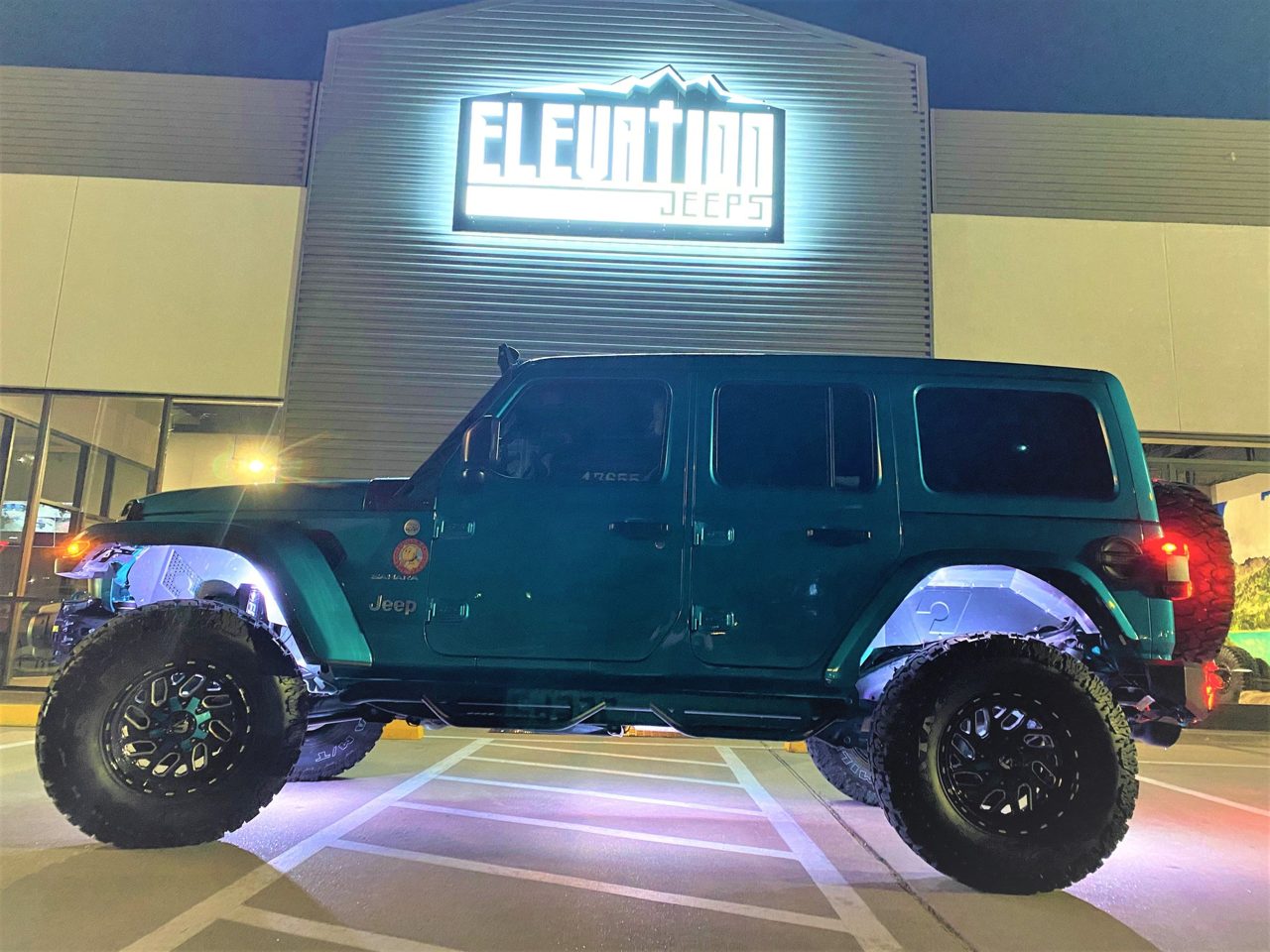 A teal Jeep Wrangler with custom lighting