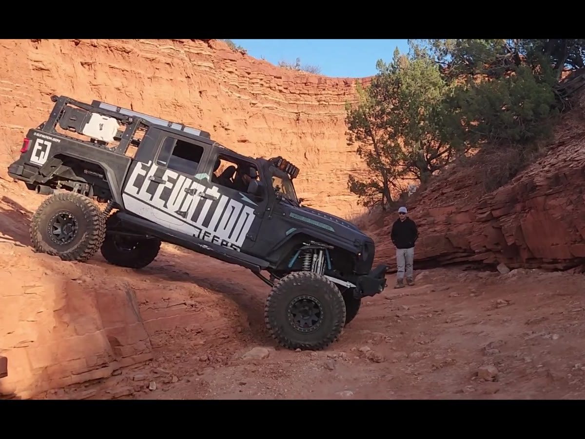 A Jeep climbing red rock on the trail