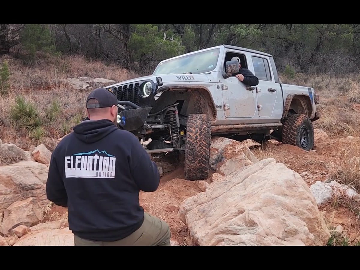A Jeep crawling red rock on the trail
